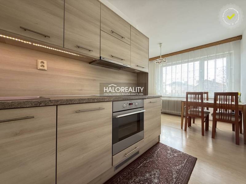A kitchen in a family house with a wooden decor floor and a dining table.