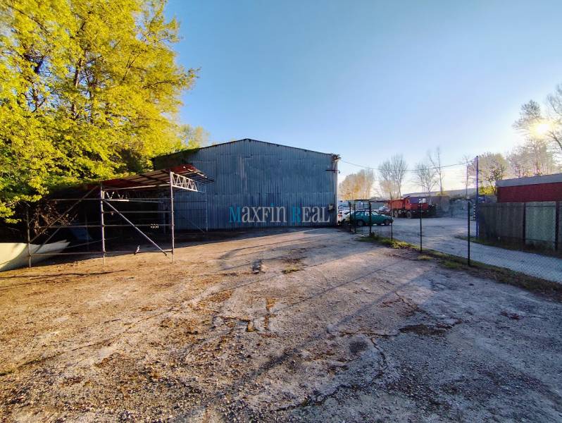An industrial property with a parking lot surrounded by trees in Nitra, suitable for commercial use.