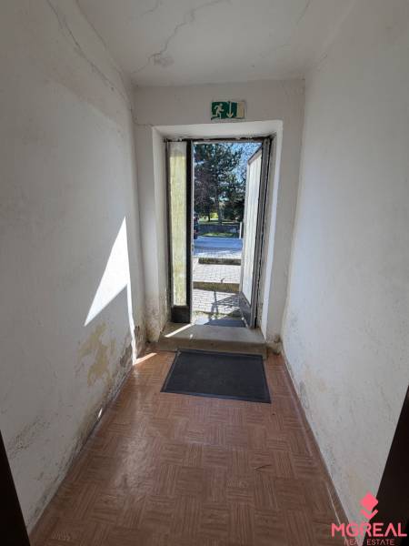 A hallway with older walls and a wooden decor floor in a family house.