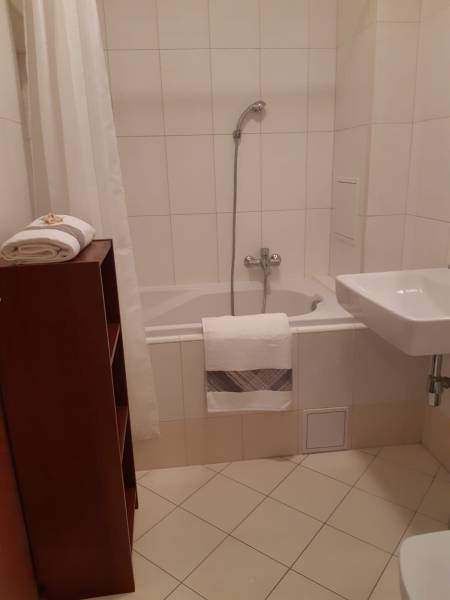 Bathroom in a 3-room apartment with a bathtub and white tiles.