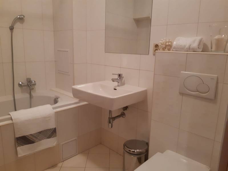 Bathroom in a 3-room apartment with a bathtub, sink, and toilet.