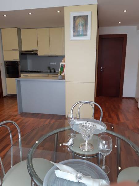 Kitchen and dining area in a 3-room apartment with a wooden decor floor.