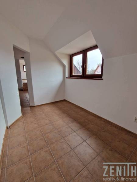 Interior of commercial premises with ceramic flooring and sloped ceiling.