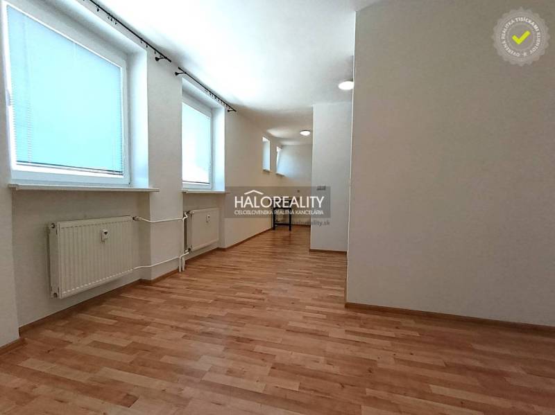 A bright room with covered windows, heating, and a wooden decor floor in a 2-room apartment.