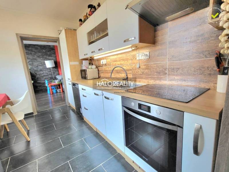A kitchen in a 3-room apartment with light cabinets and a wood-patterned floor.