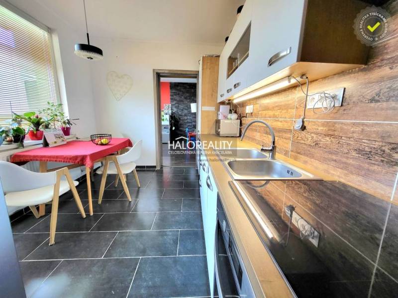Kitchen in a 3-room apartment with ceramic tiles and a wooden decor floor.