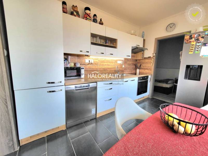 A kitchen in a 3-room apartment with a wooden decor floor and appliances.