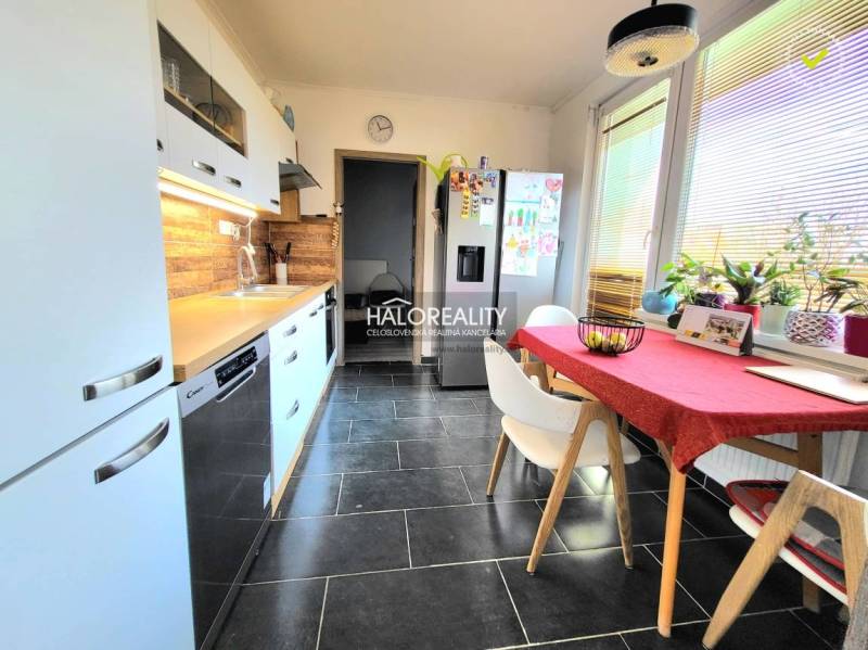 A kitchen in a 3-room apartment with tiles and wooden decor, bright and spacious.