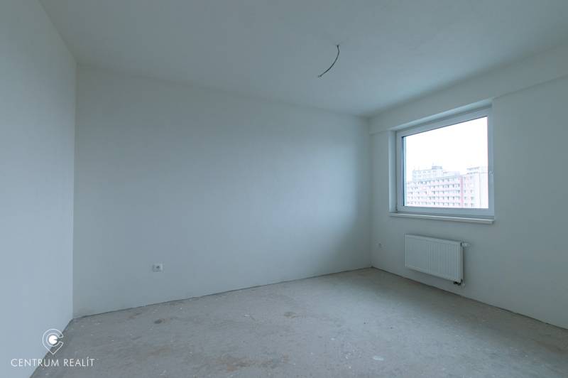 An empty room with white walls in a 2-room apartment, large window, radiator.