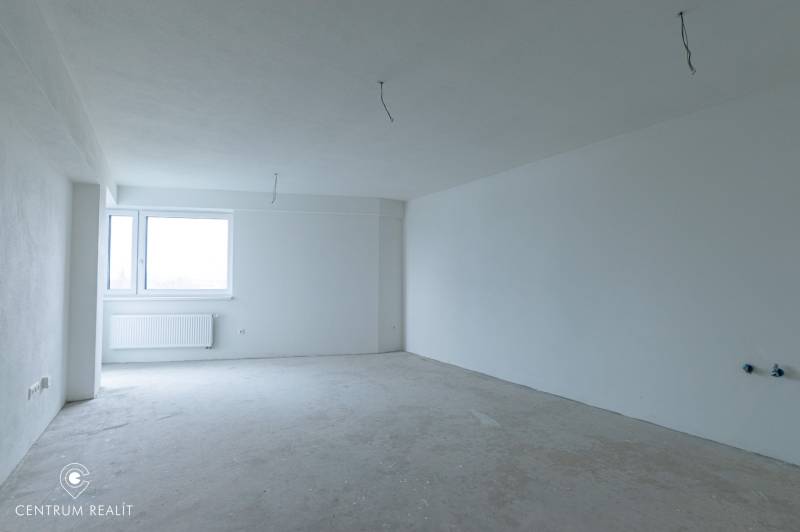 Empty room in a two-room apartment with a window and white walls without furniture.