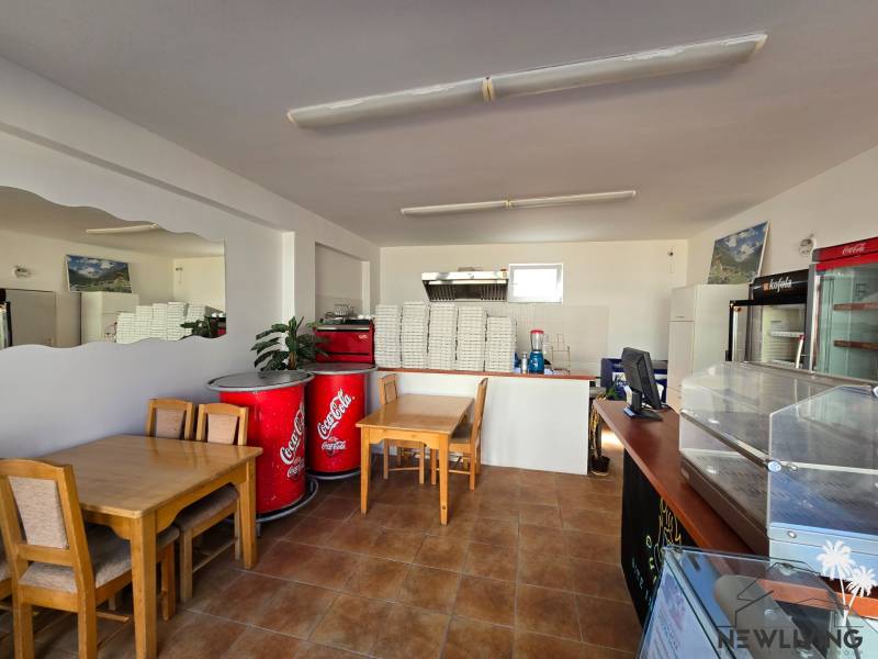 Gastro premises with a wooden decor floor, tables, and refrigerators.