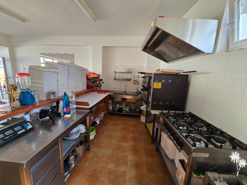 The kitchen of gastro spaces with professional appliances and supplies on wooden decor flooring.