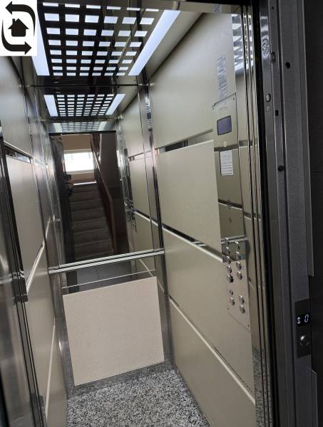 Elevator with a mirror and a grid ceiling in a 4-room apartment.