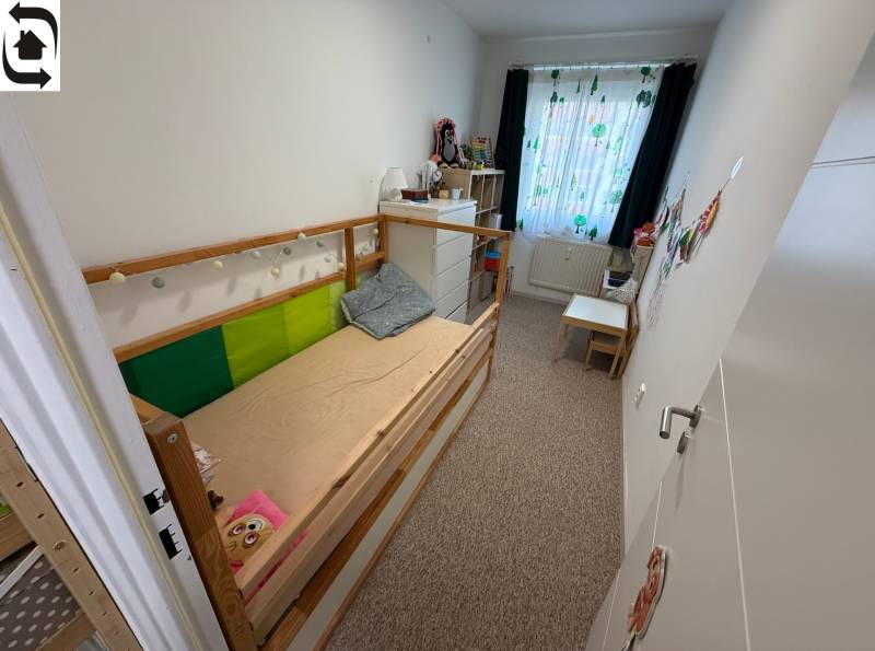 Children's room in a 4-room apartment with a bed, dresser, and colorful curtains.