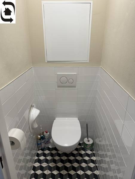 A bathroom in a 4-room apartment with geometric tiles and white tiles.