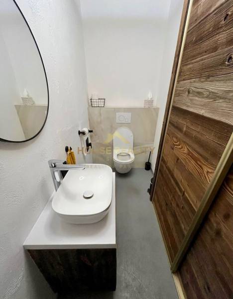 A bathroom in a 3-room apartment with a mirror, sink, and modern decoration.