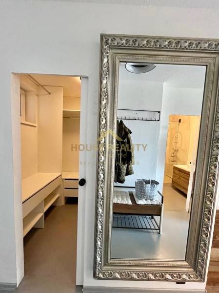 A mirror with a decorative frame and a spacious dressing room in a 3-room apartment.