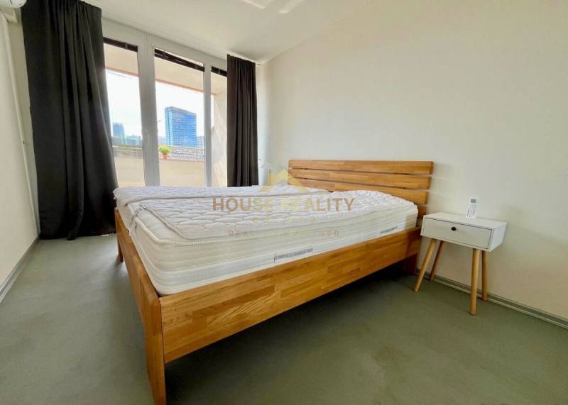 A bedroom with a wooden bed, a nightstand, and a balcony in a 3-room apartment.