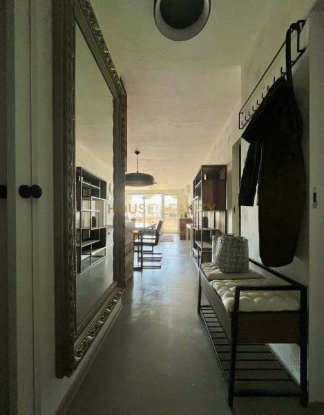 A hallway with a large mirror, coat racks, and a bench in a 3-room apartment.