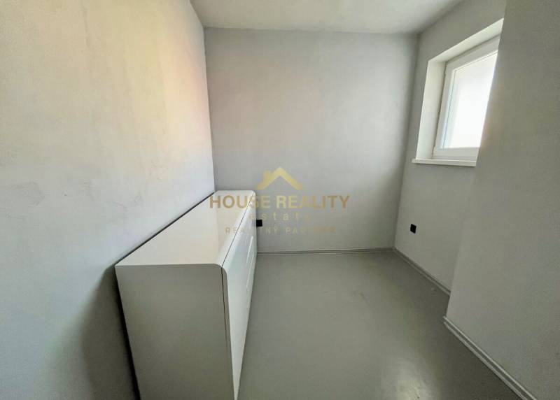 A small room with a dresser in a 3-room apartment, with white walls and a window.