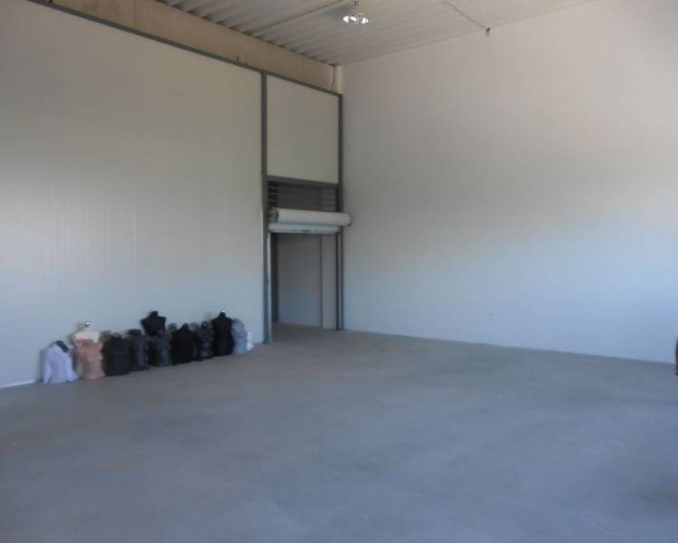 Spacious interior of warehouses and halls with concrete floor and bags along the wall.