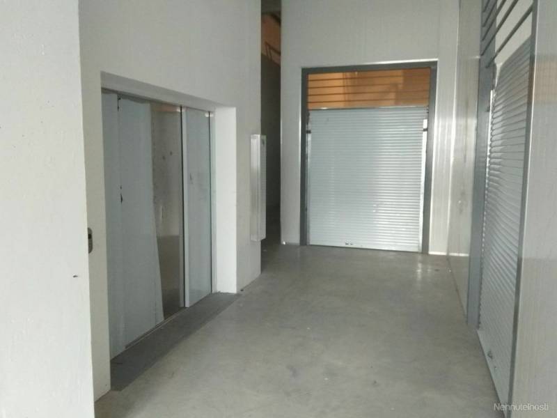 Interior in a warehouse and hall with white and metal surfaces.