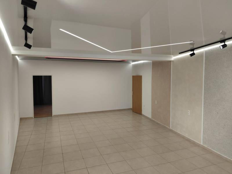 Commercial spaces with white walls, ceiling lights, and ceramic tiles.