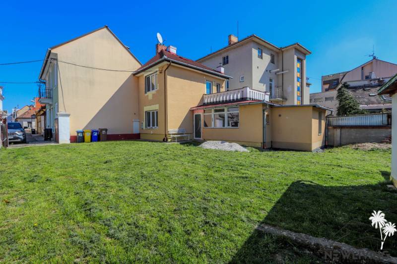 A family house on Hviezdoslavova Street in Piešťany with a grassy yard and a bench.