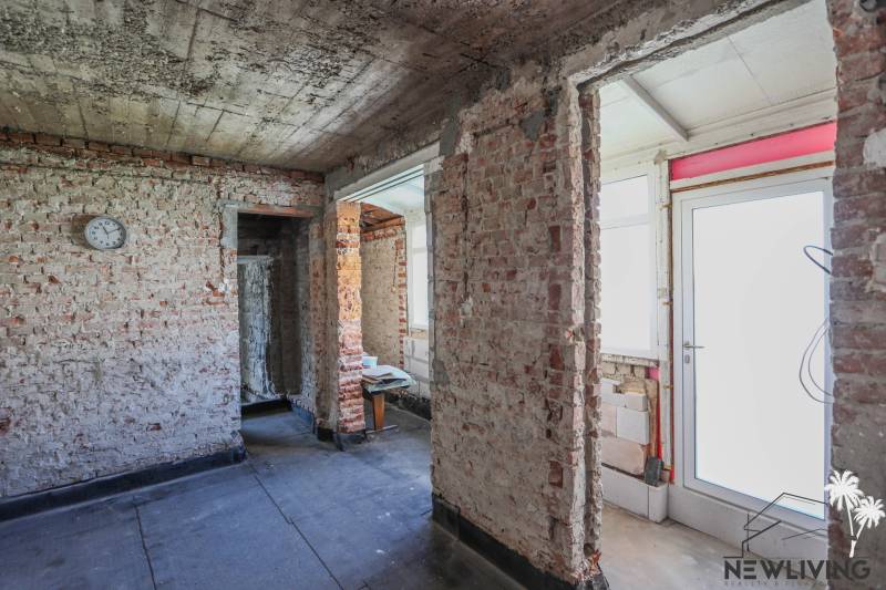 A family house with unfinished brick walls and white doors, concrete floor.