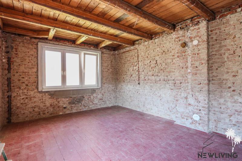 Interior of a family house with brick walls and a window, floor with wooden decor.