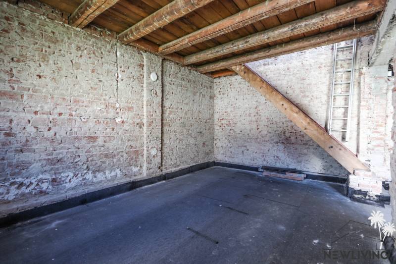 Room with brick walls and wooden beams in a family house.
