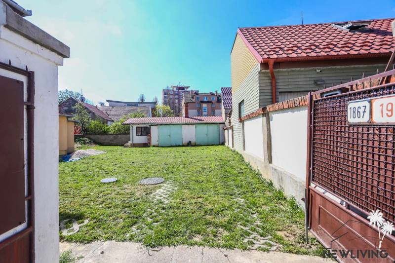 The courtyard of a family house on Hviezdoslavova Street in Piešťany with a grassy area and a shelter.
