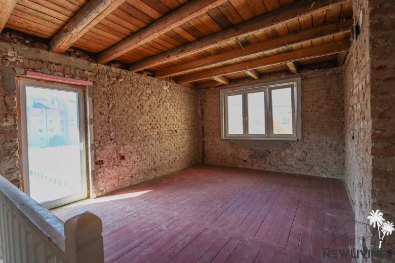 Interior in a family house with brick walls and large windows, floor with wooden decor.