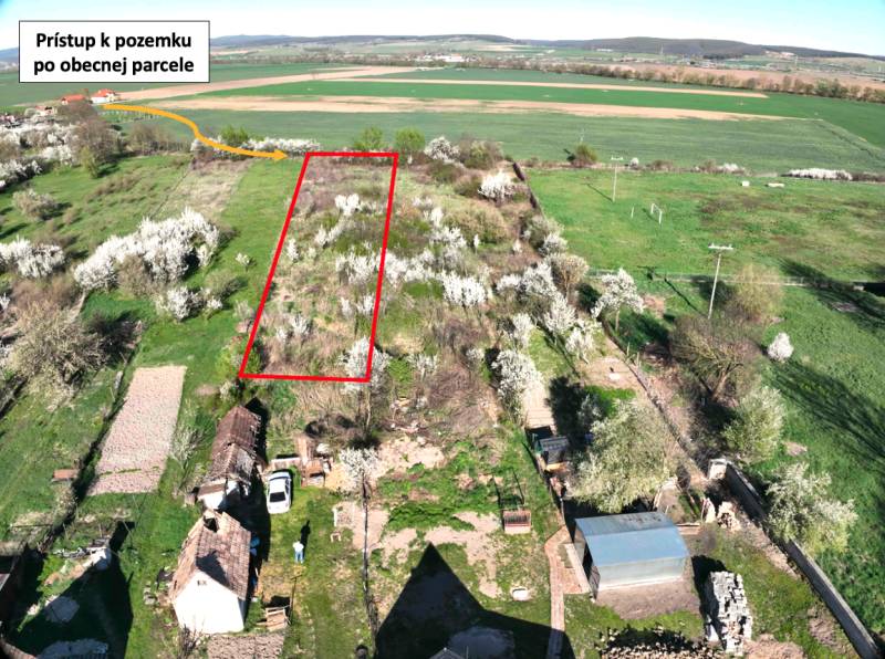 Garden plot in Gemer with an access road, surrounded by blooming trees and fields.