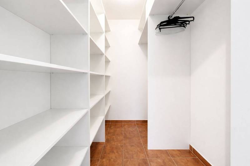 Entrance hall with built-in shelves and hangers, in a 3-room apartment with tiled flooring.