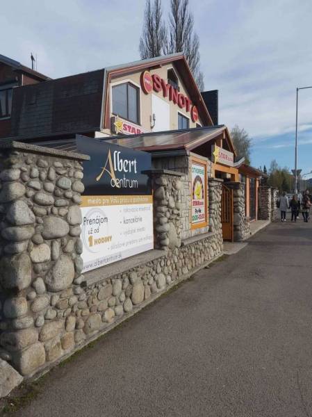 Offices in Poprad with a stylish stone facade and an advertisement for space rental.