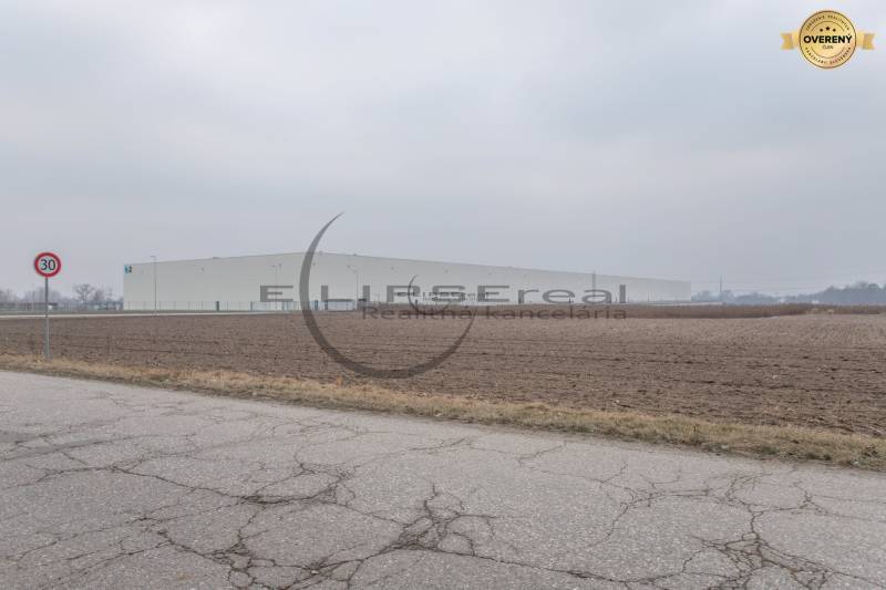 Commercial land on Priemyselná Street in Zohor, next to a large building and road.
