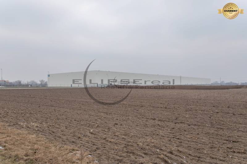Industrial Street in Zohor, extensive commercial plots with a large building in the background.
