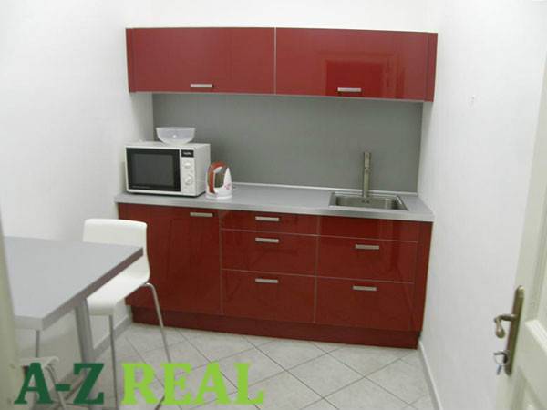 Offices with a red kitchen unit, microwave, and dining table.