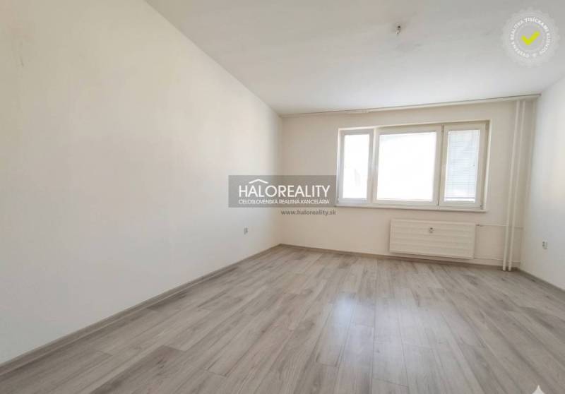 A room in a 3-room apartment with a wooden decor floor and white walls.