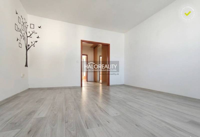 A room in a 3-room apartment with a wooden decor floor and a decorative wall mural.