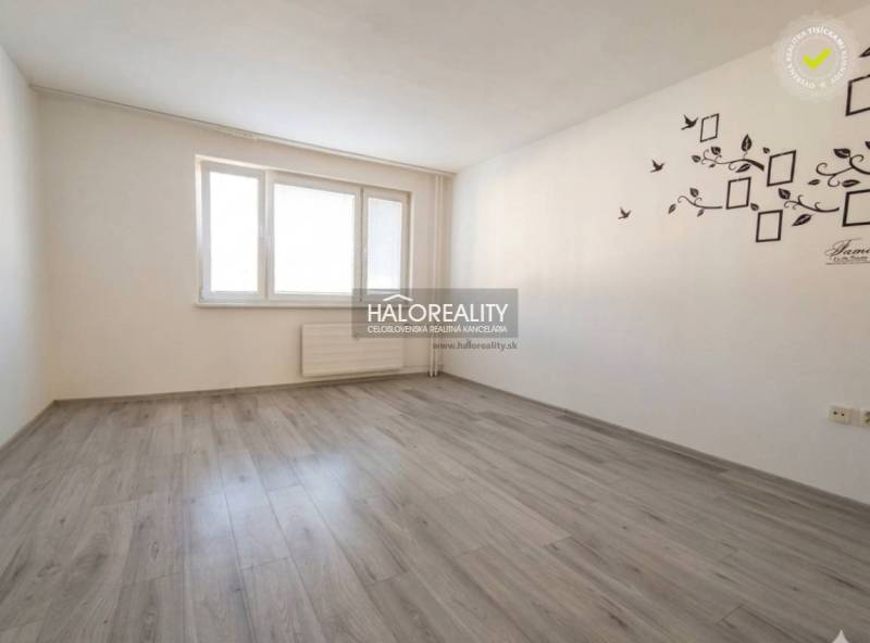 A room in a 3-room apartment with a wooden decor floor and white walls.