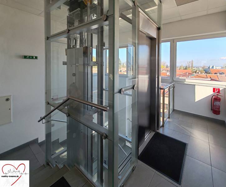 Glass elevator in offices with a view of the rooftops of Trnava.