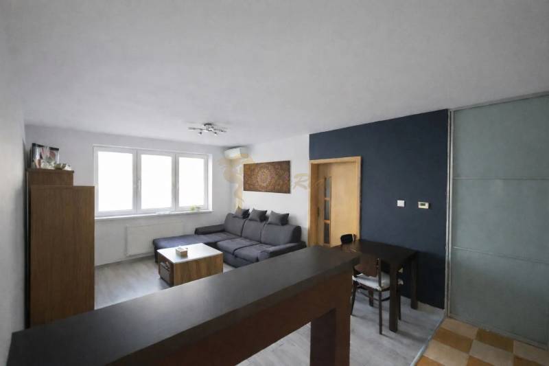 Living room in a three-room apartment with a corner sofa and a floor with a wooden decor.