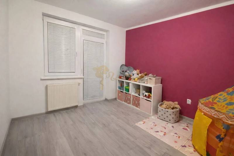 A children's room in a three-room apartment with a wooden decor floor and colorful walls.