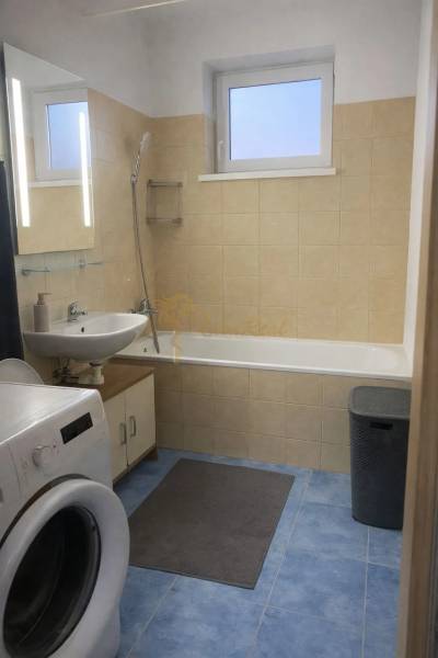 A bathroom with a bathtub, sink, and washing machine in a 3-room apartment, blue tiles.