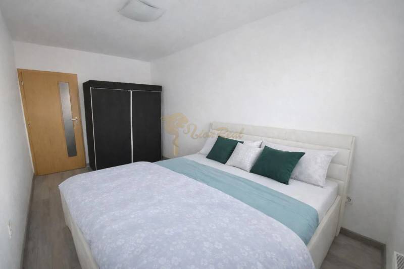A bedroom with a bed, built-in wardrobe, and wooden decor flooring in a 3-room apartment.