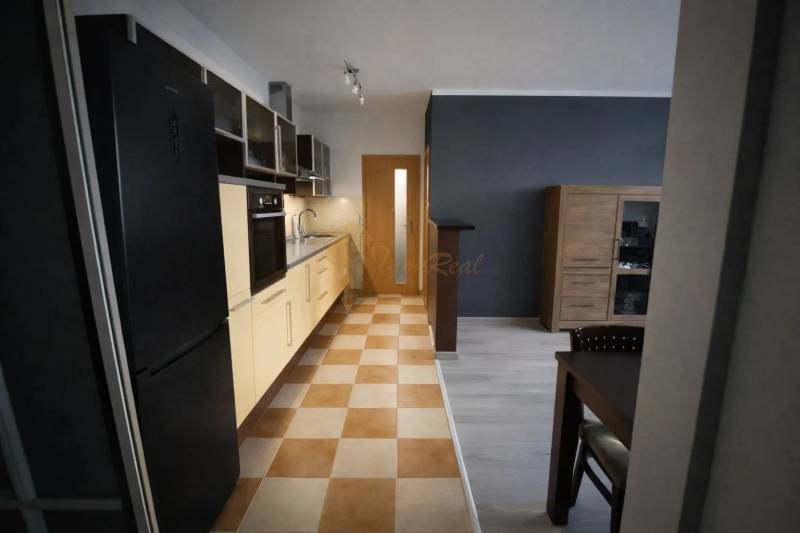 A kitchen in a 3-room apartment with a kitchen unit and a dining table, tiled floor.