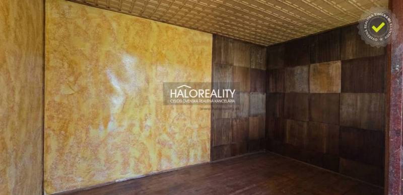 A room in the Gardens with a wood-patterned floor and yellow walls.