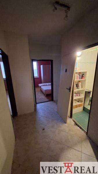 The entrance hall of a 3-room apartment with a view into other rooms, the floor is tiled.
